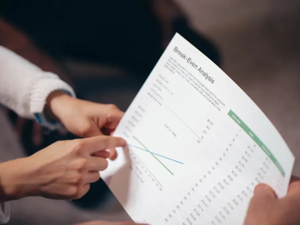 Diskusi analisis break even point dengan dokumen keuangan di rapat bisnis